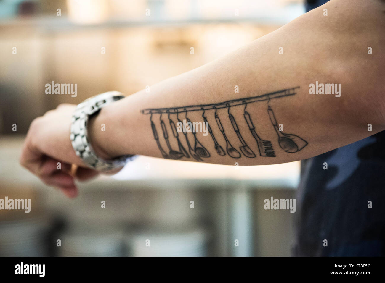 Kitchen utensils tattooed on arm Stock Photo