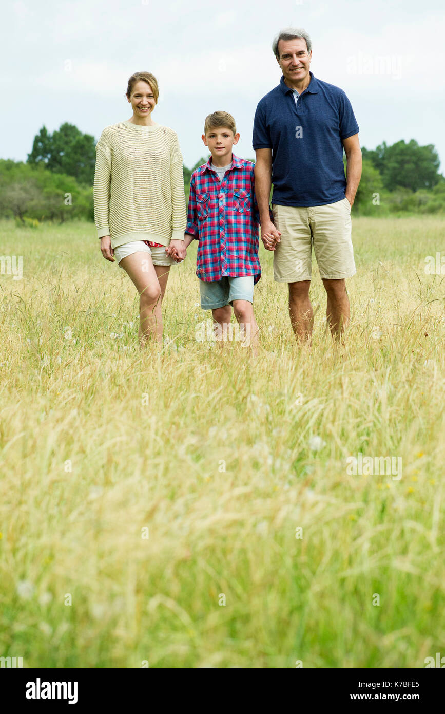 Family with one child on walk together in open field Stock Photo