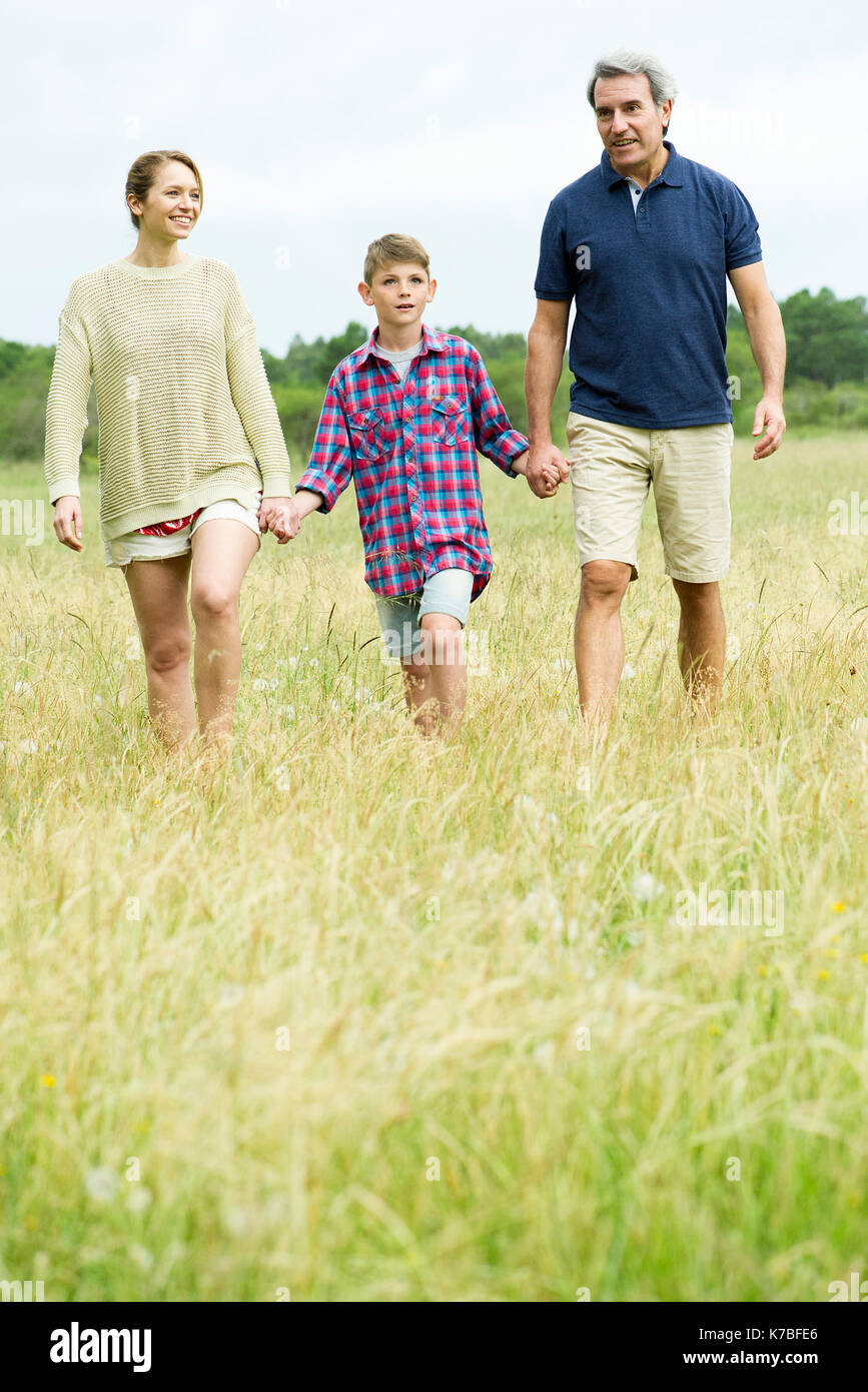 Family with one child on walk together in open field Stock Photo