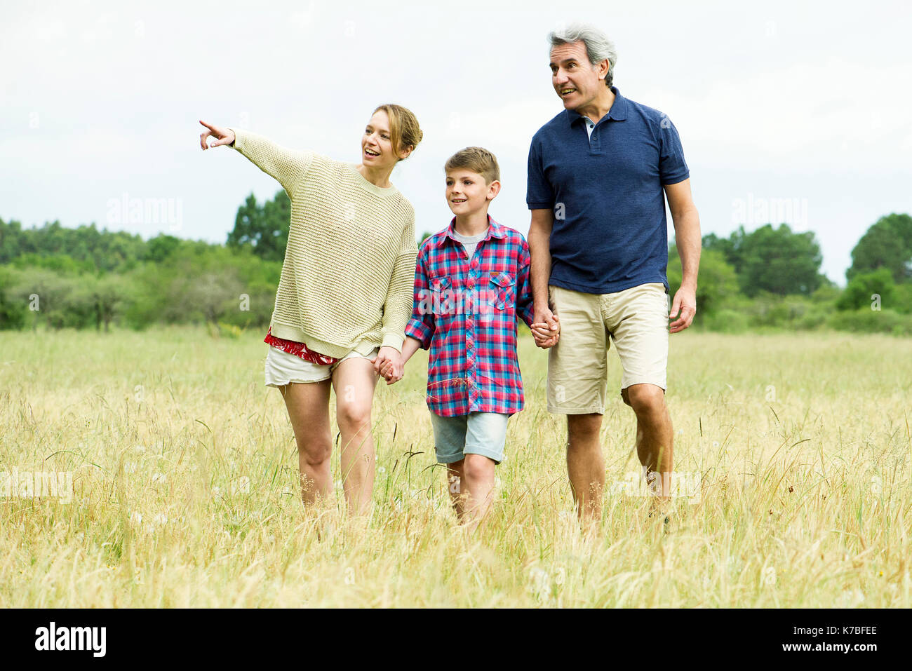 Family with one child on walk together in open field Stock Photo