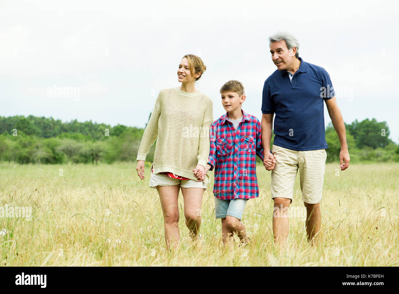 Family with one child on walk together in open field Stock Photo