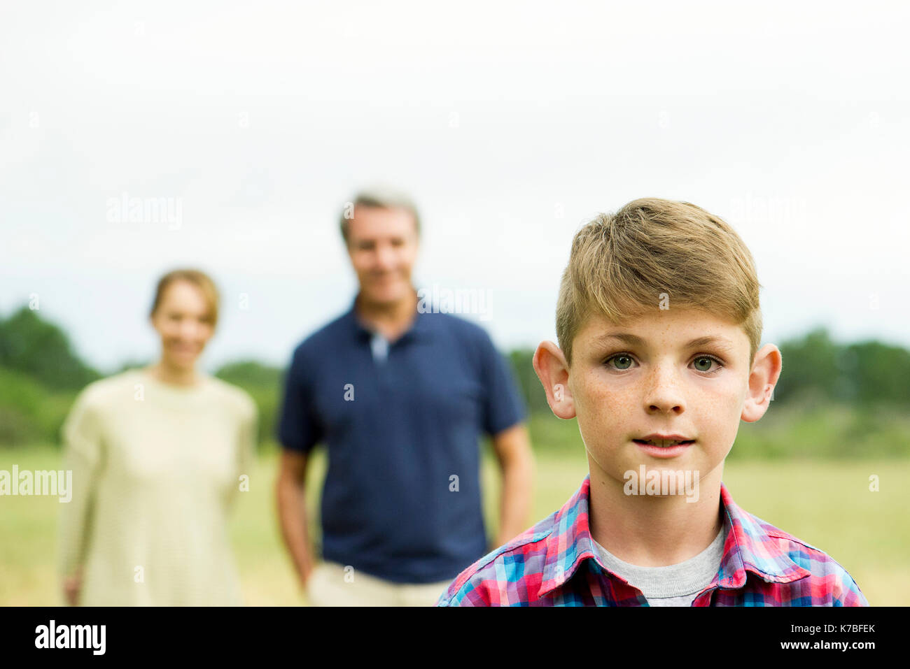 Boy with parents in background, portrait Stock Photo