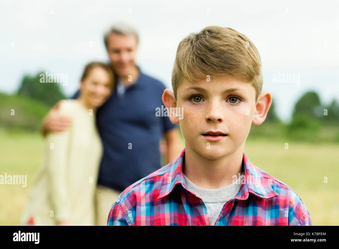 Boy with parents in background, portrait Stock Photo