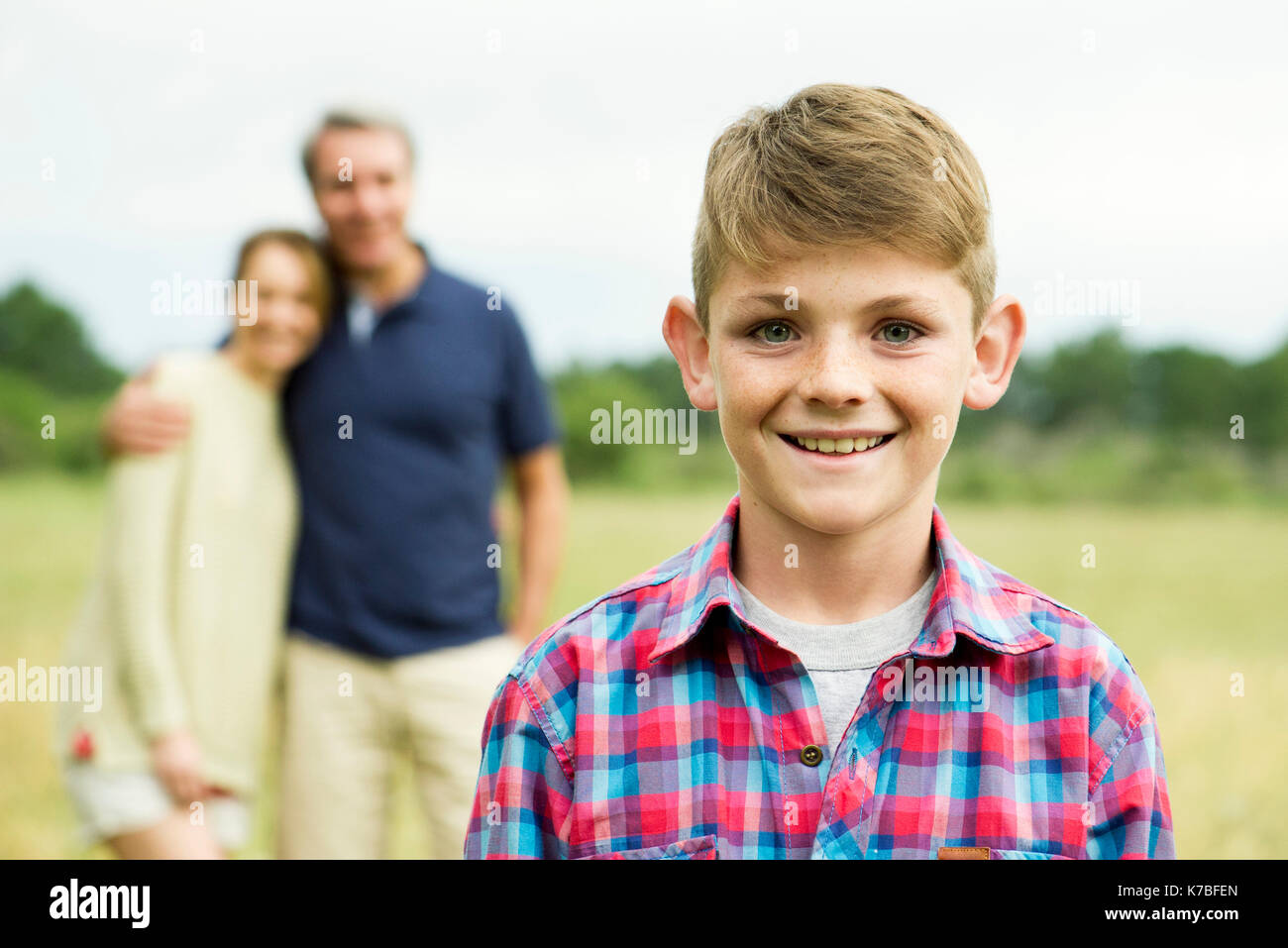 Boy with parents in background, portrait Stock Photo