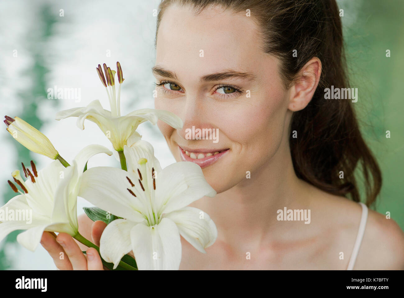 Young woman smelling lilies Stock Photo Alamy