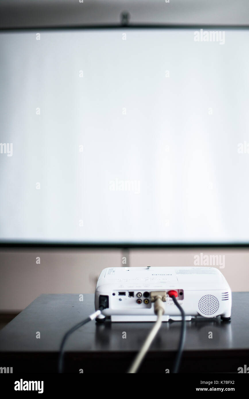 Video projector and blank screen in office or classroom Stock Photo