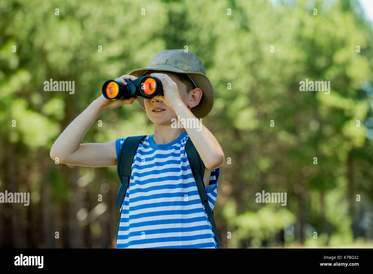Boy looking through binoculars outdoors Stock Photo