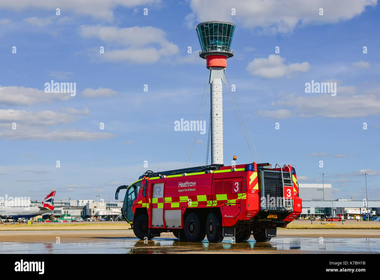 London Heathrow Airport Emergency Fire Truck  Next to the Air Traffic Control Tower Stock Photo