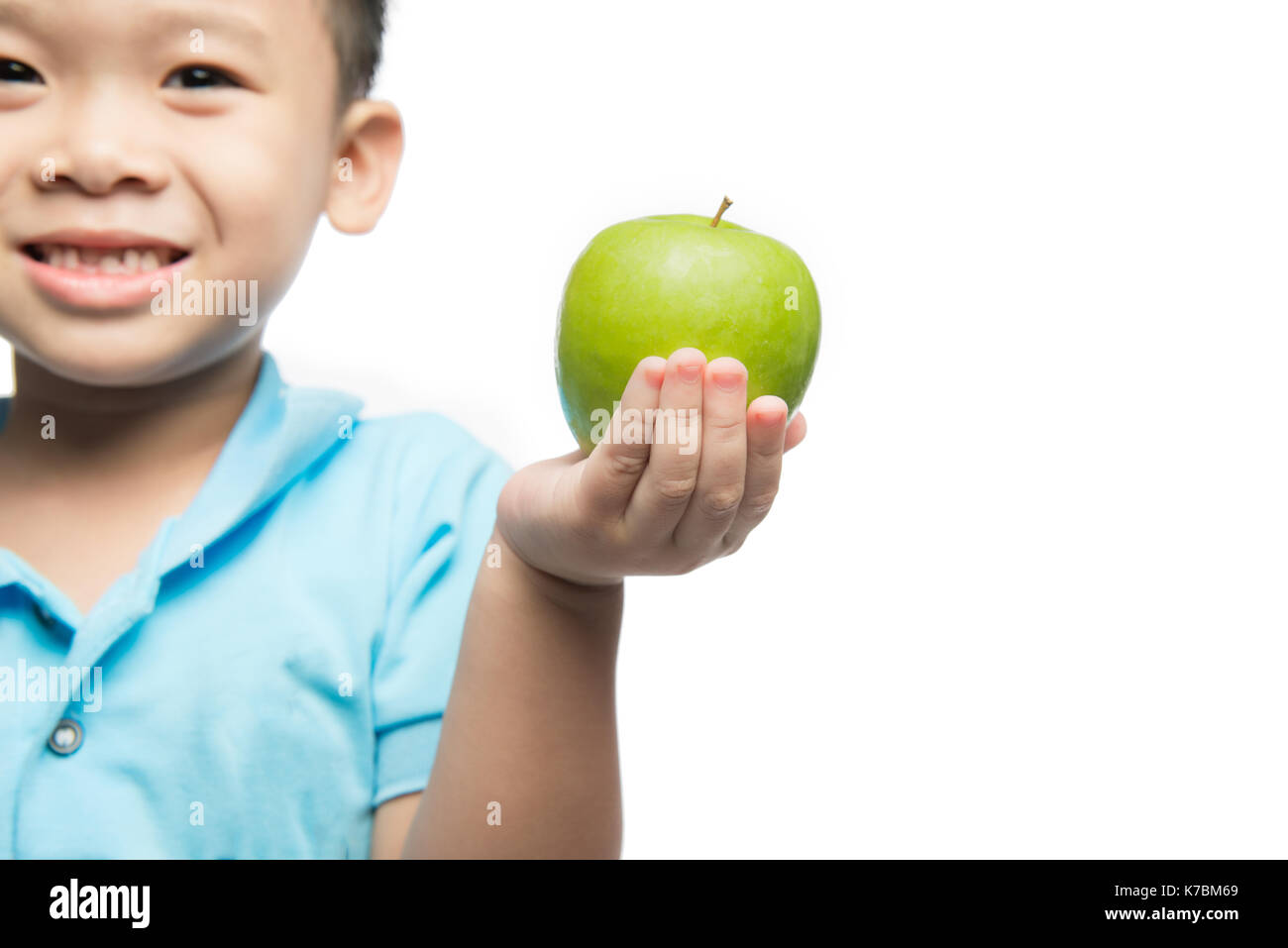 Asian baby boy holding and eating red apple, isolated on white Stock Photo