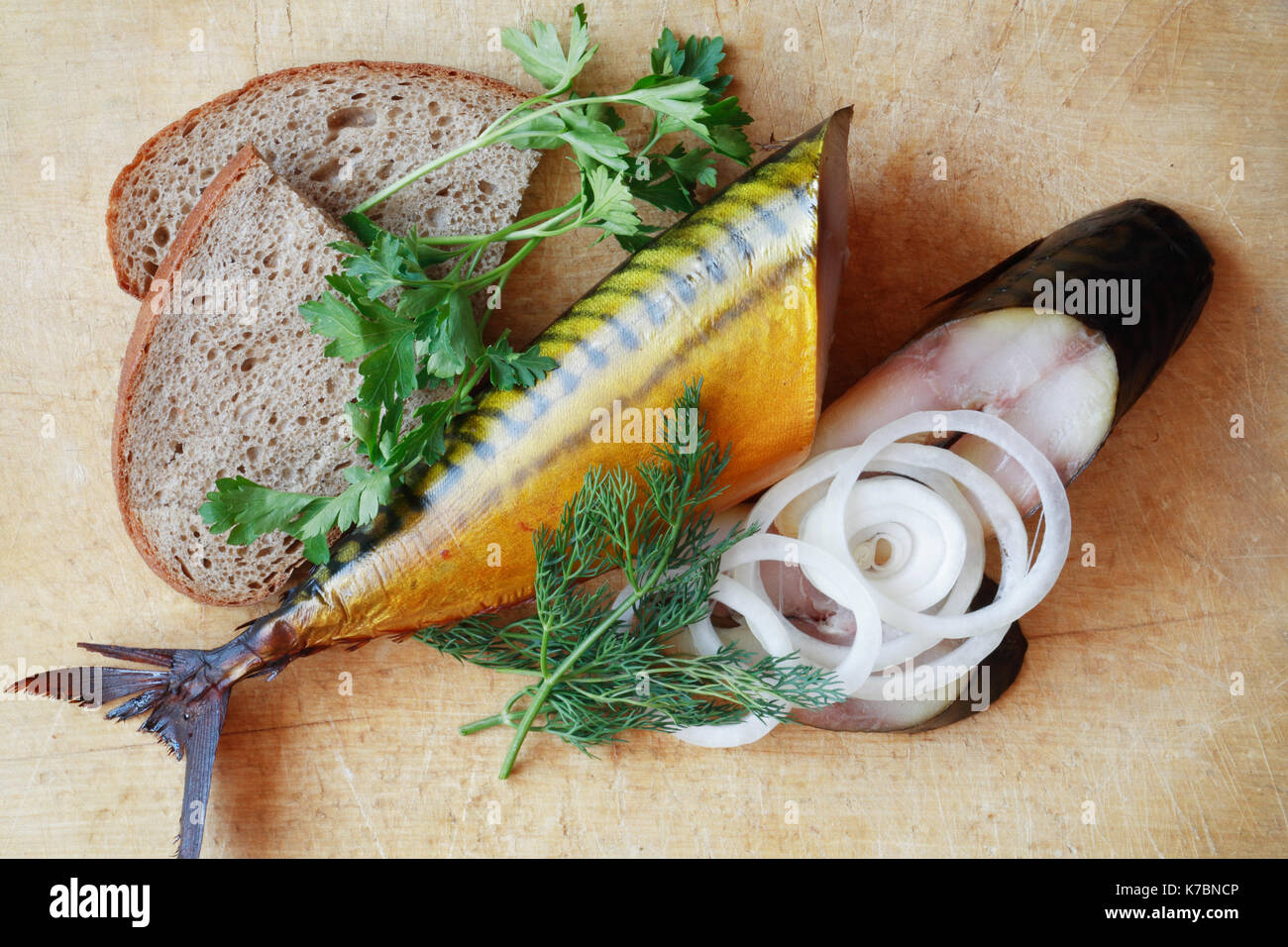 Sliced bloated fish and bread on wooden surface Stock Photo