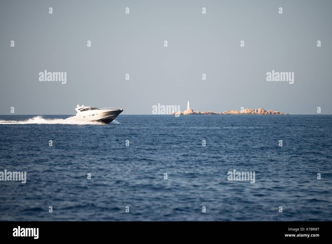 Small motor boat on sea, small island in background Stock Photo