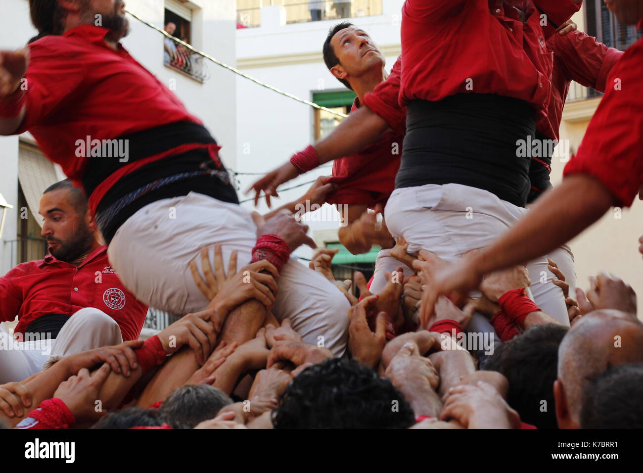 People making human towers, a traditional spectacle in Catalonia called 'castellers', with people climbing and m Stock Photo