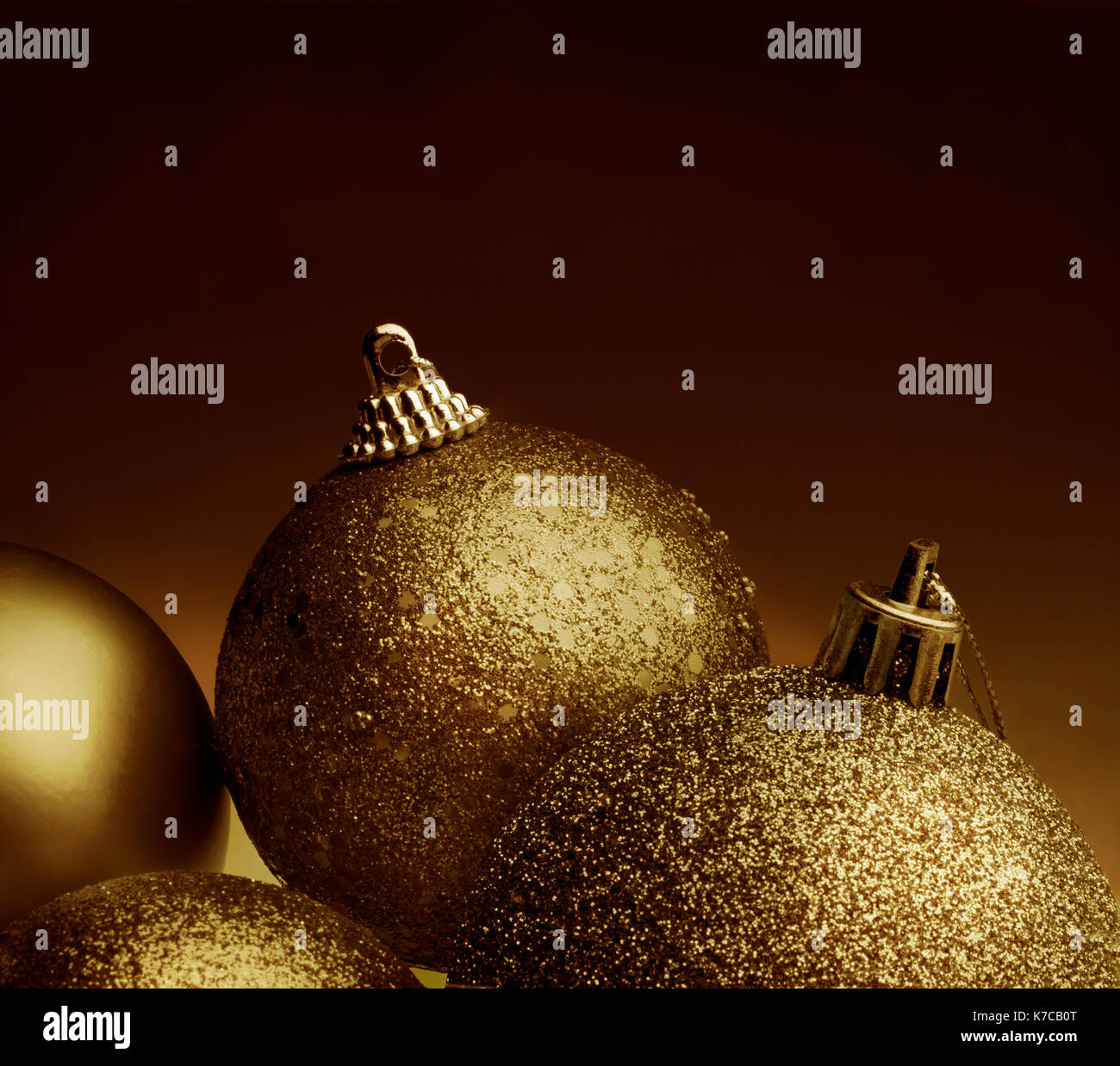 Close up view of golden color christmas balls against a bronze color background Stock Photo