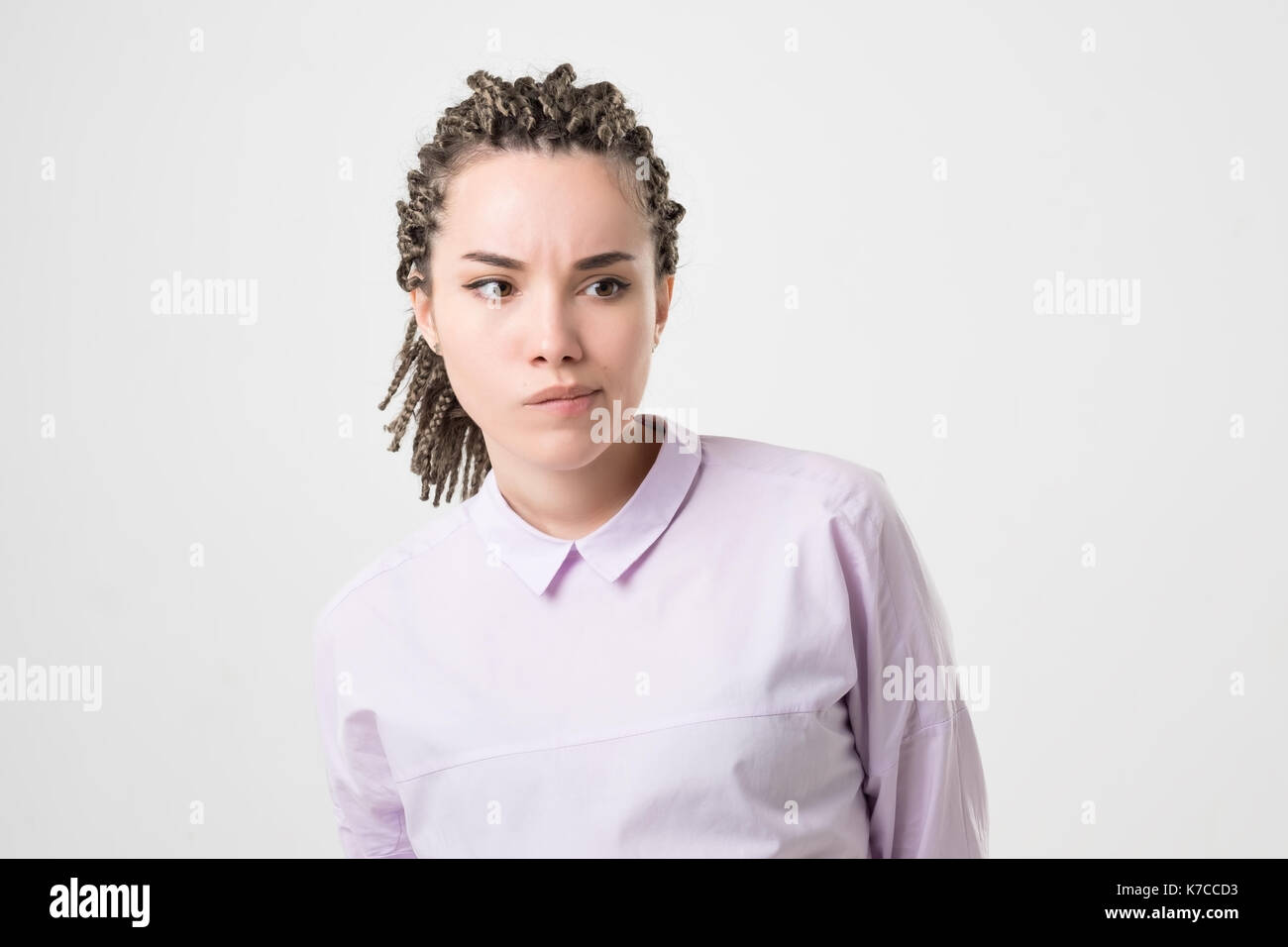 Pensive doubtful caucasian girl with braids looking sideways, feeling unsure. She making an important decision Stock Photo