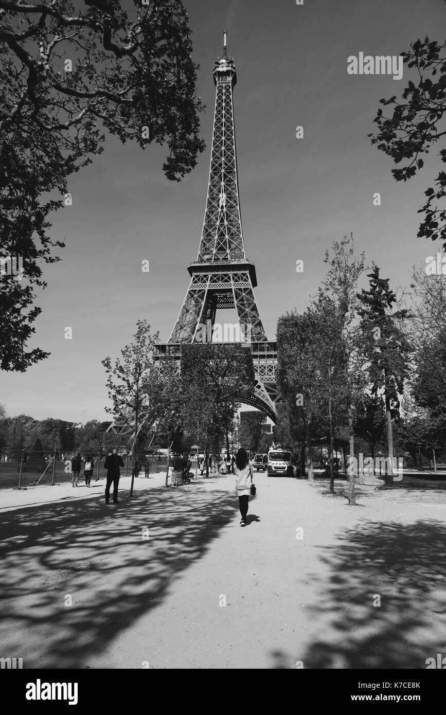 A woman standing in front of the Eiffel Tower in Paris, France. Stock Photo