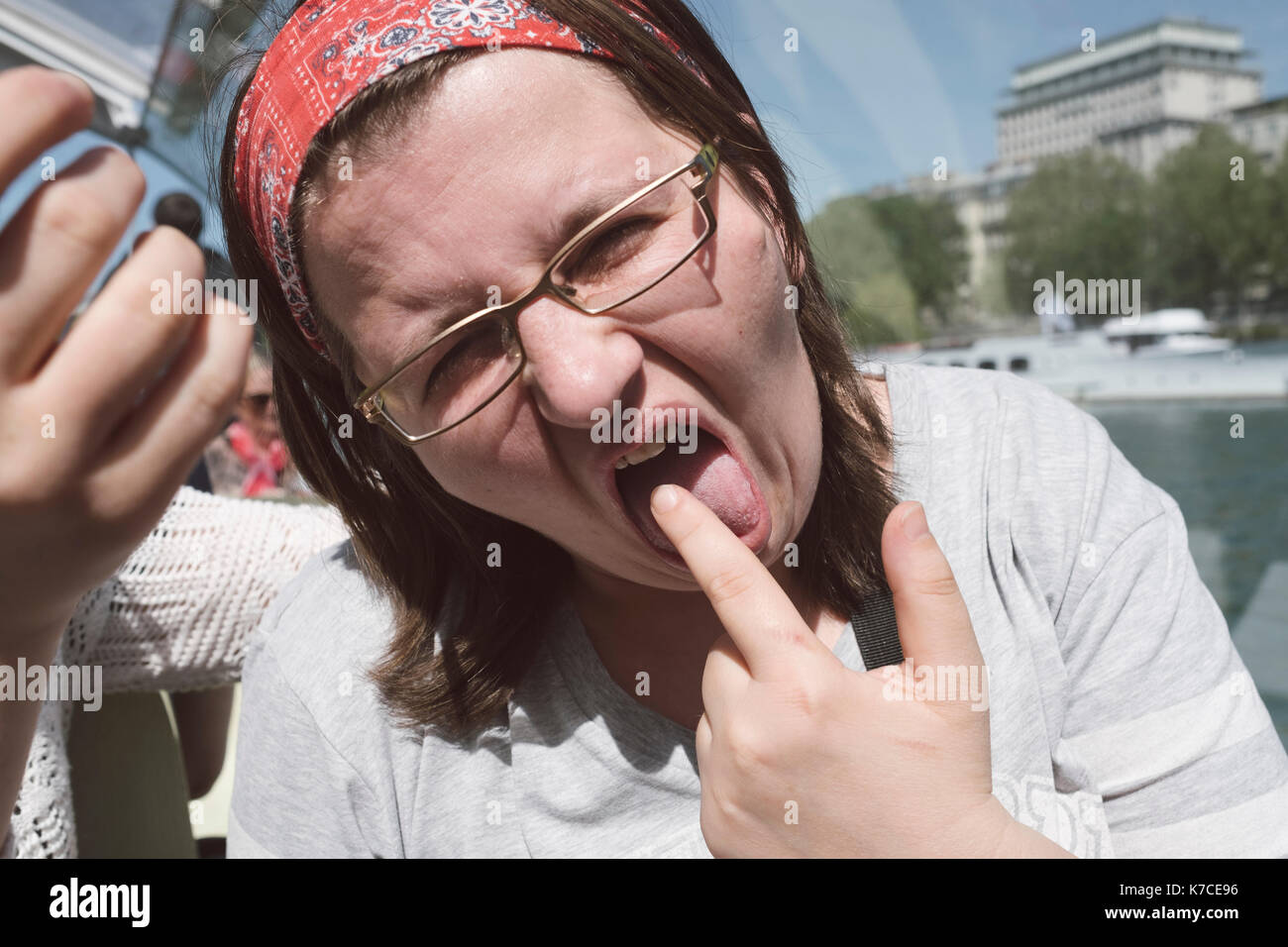A woman making funny face by sticking her tongue out Stock Photo