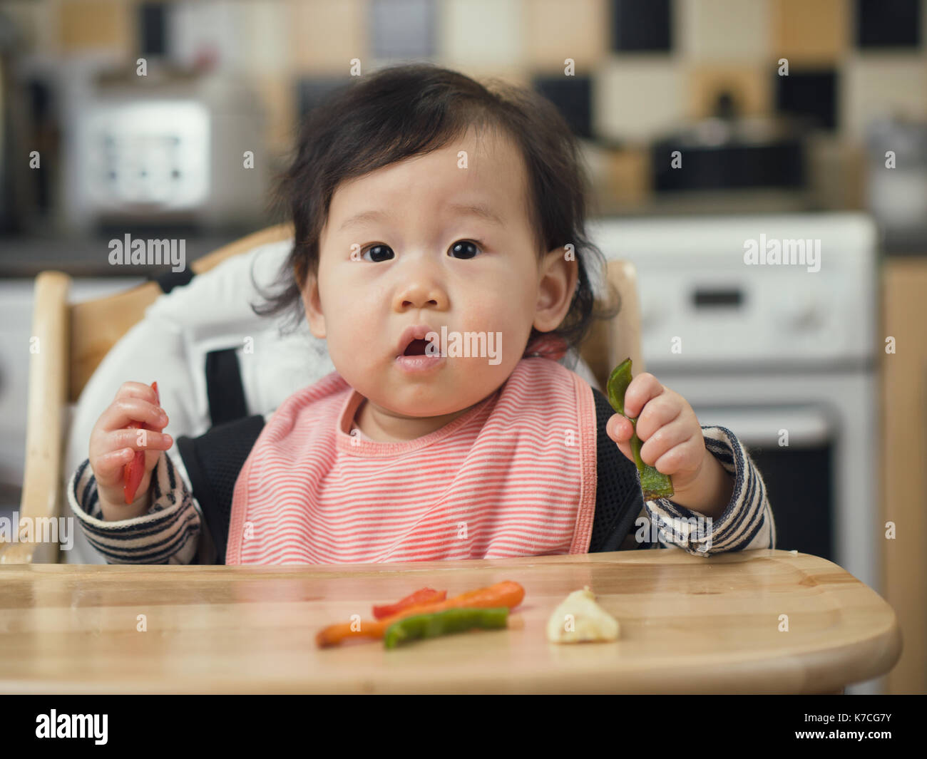 https://c8.alamy.com/comp/K7CG7Y/asian-baby-girl-eating-roasted-vegetable-at-home-kitchen-K7CG7Y.jpg