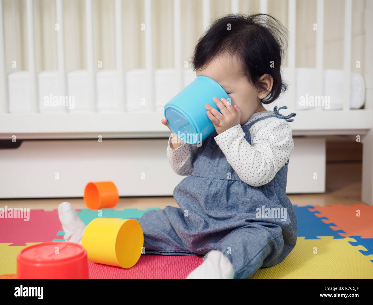 Baby girl playing stack cups at home Stock Photo Alamy
