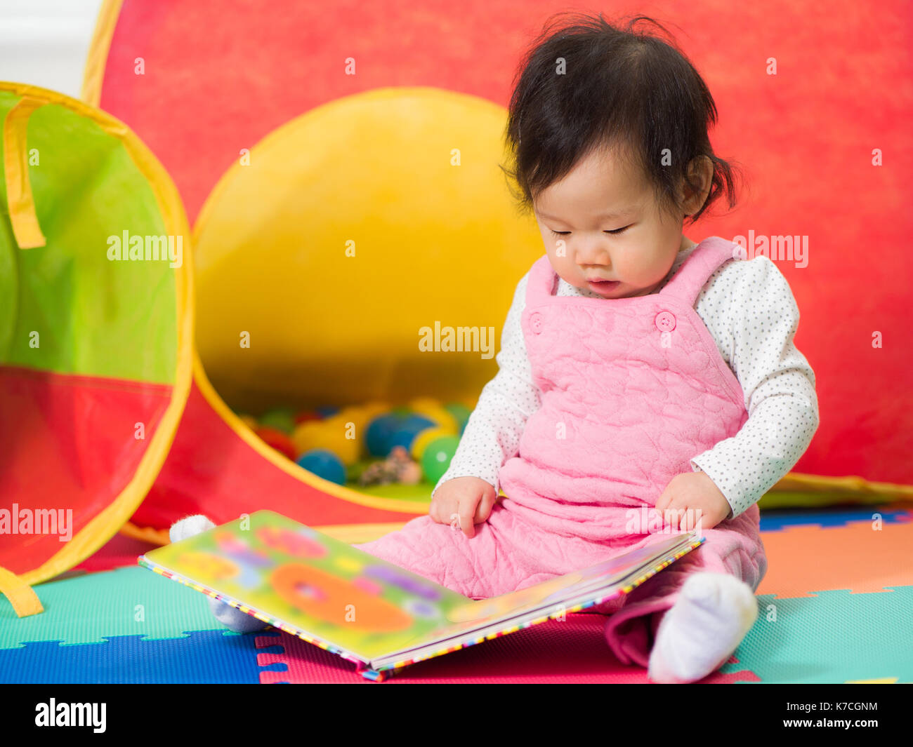cute baby girl sit on floor and reading book by herself Stock Photo - Alamy