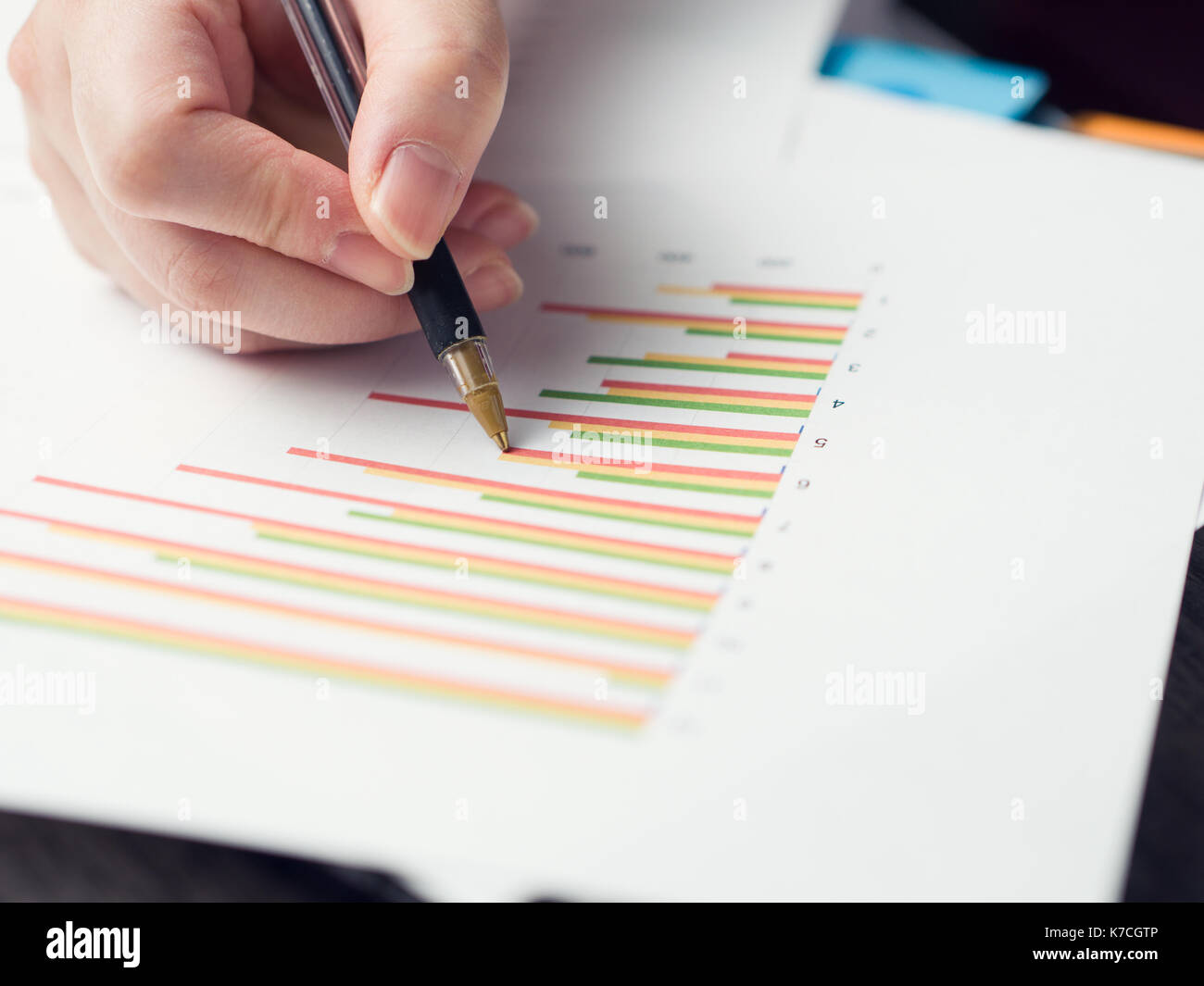 Business man hold a pen on bat chart Stock Photo - Alamy