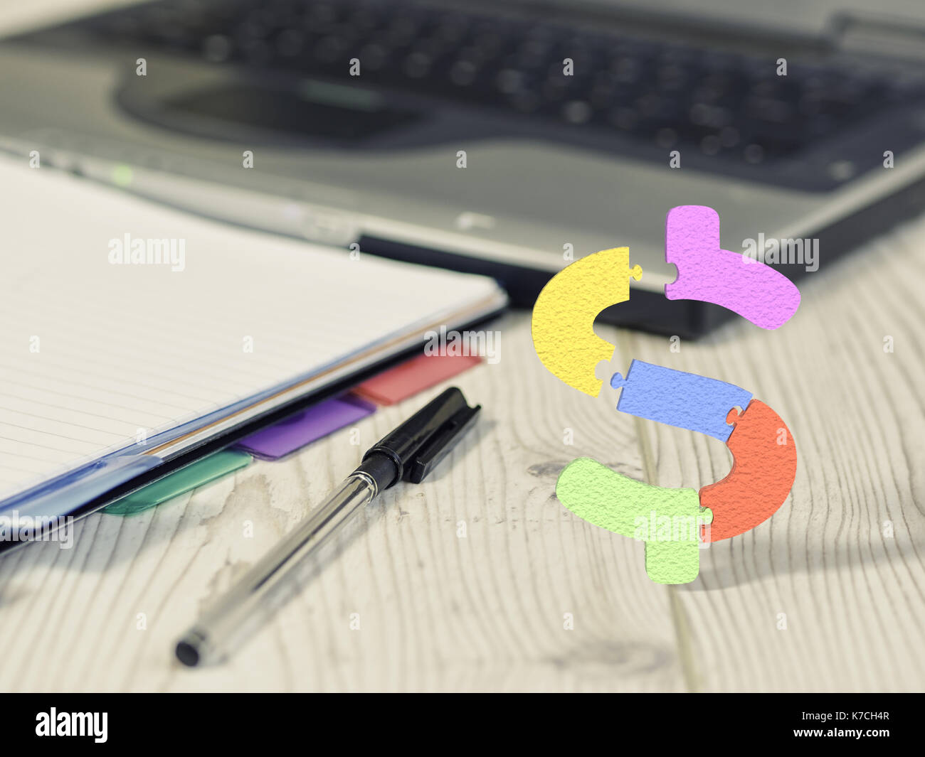 Laptop Pen And Notebook On Office Desk With Dollar Sign Puzzles