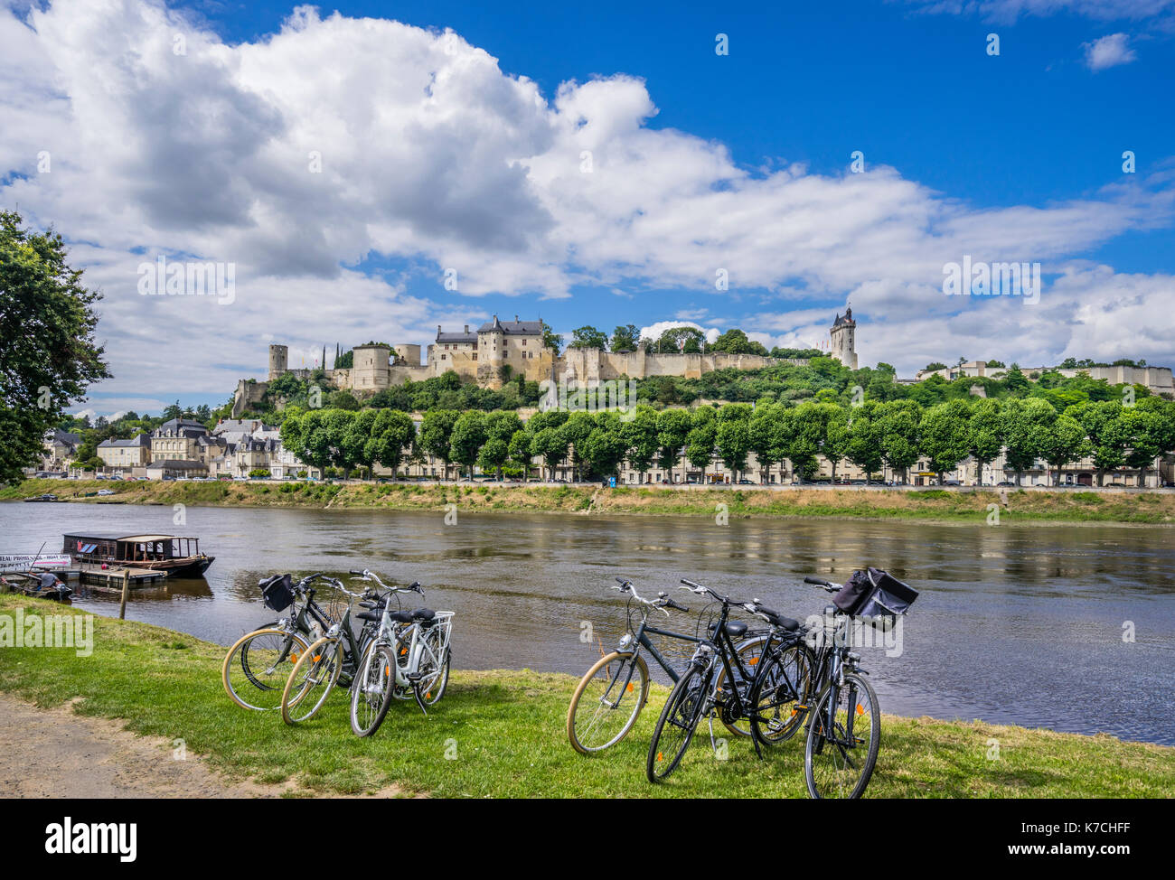 France, Centre-Val de Loire, Touraine, Chinon, cycling on the banks of the Vienne River against the backdrop of Château de Chinon on a rocky outcrop a Stock Photo