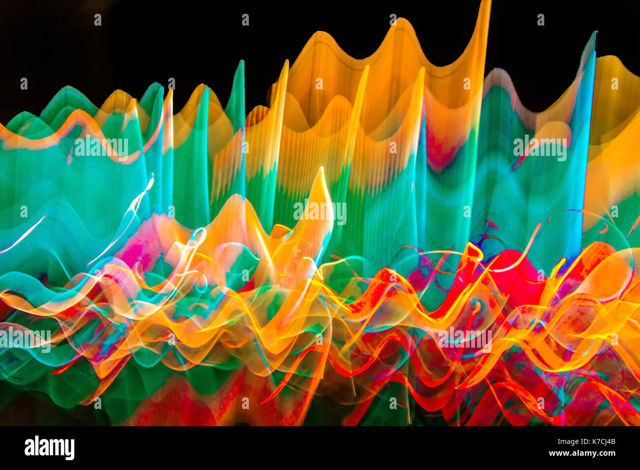 Abstract photo of wavy color lights in motion with a black background.. Stock Photo