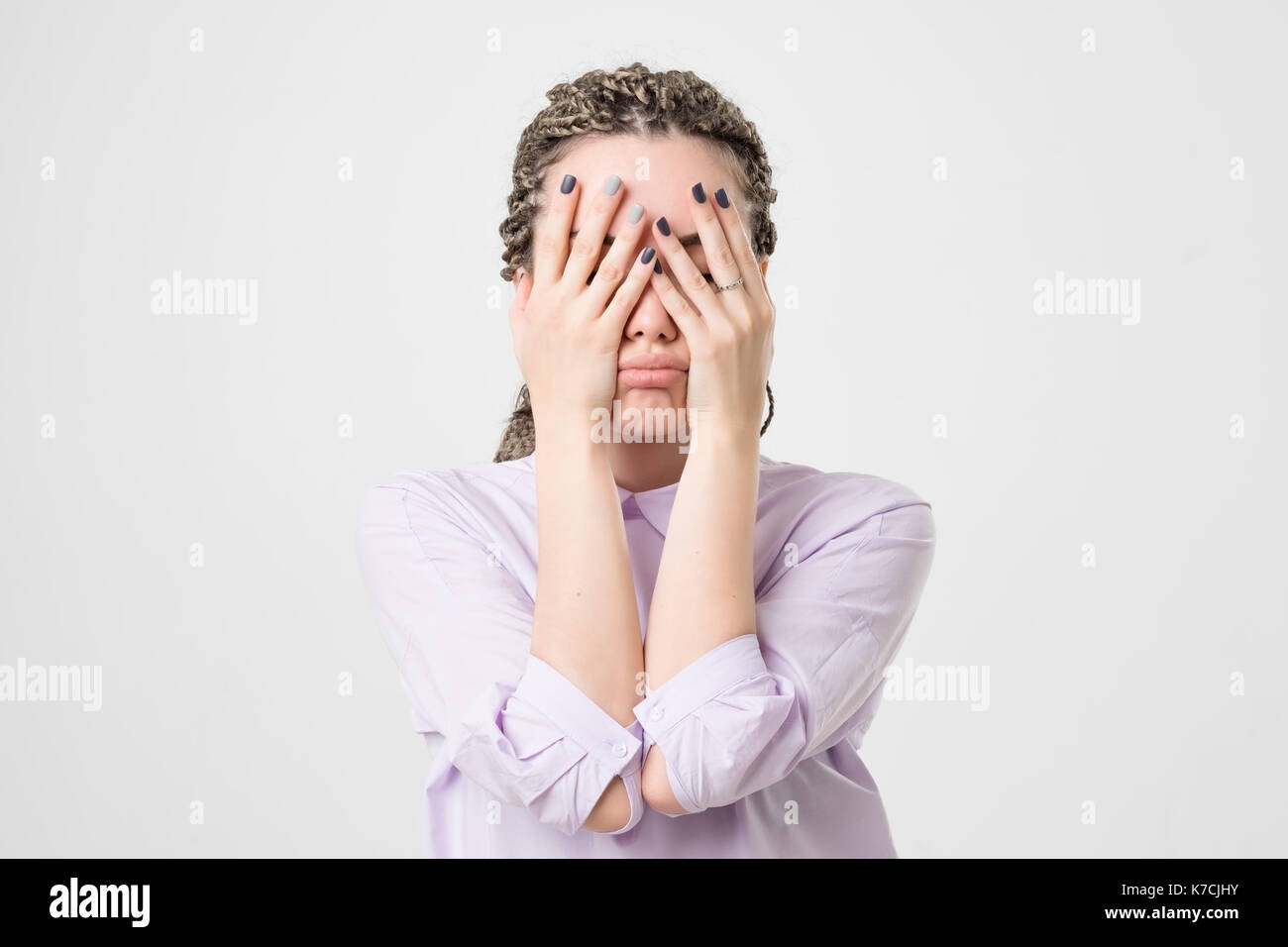 Caucasian woman covering her face with hand. Stock Photo