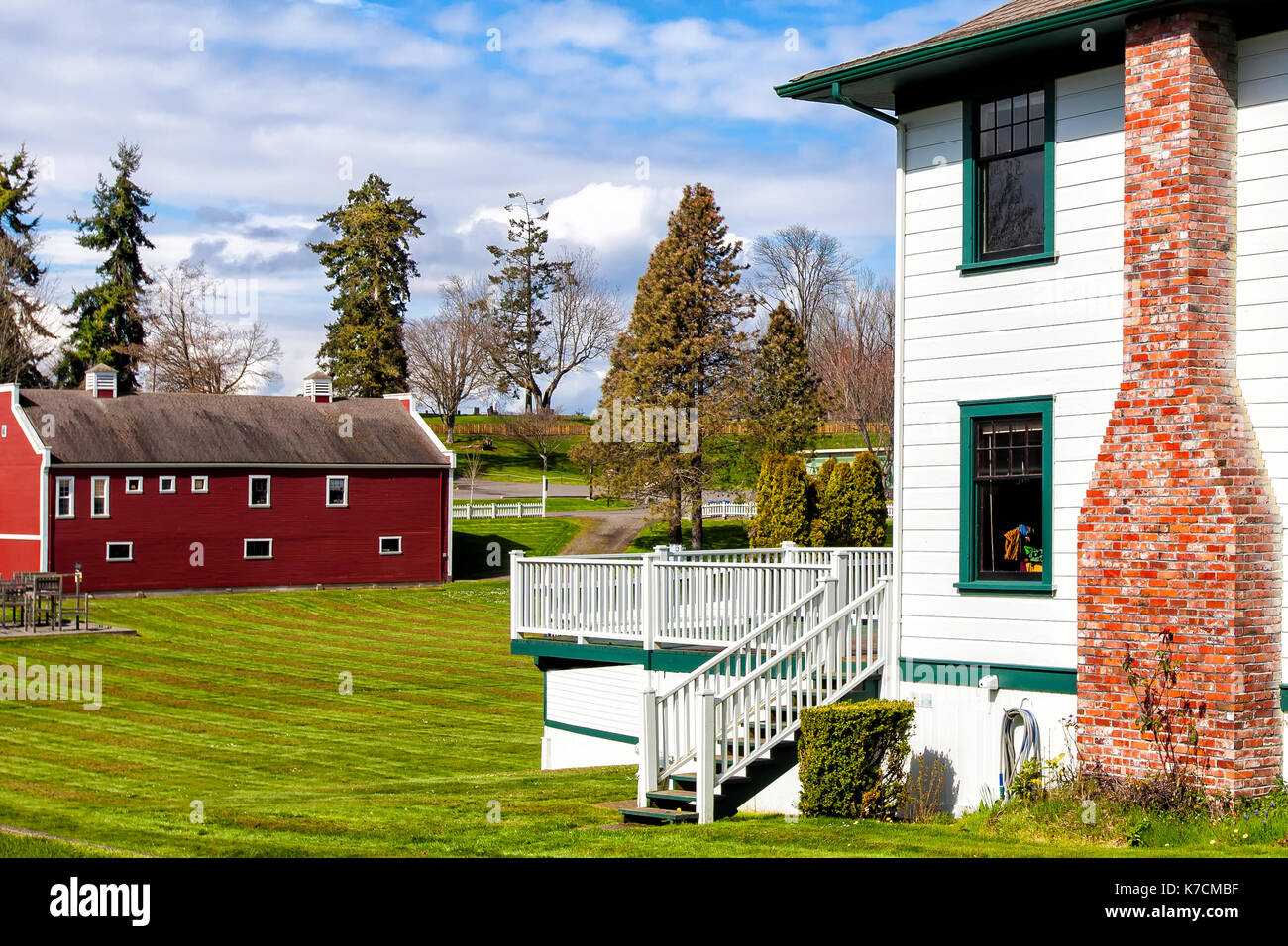American farm house and red barn architecture. Exterior view. Location: Northwest USA, Olympic Peninsula, Port Gamble Stock Photo