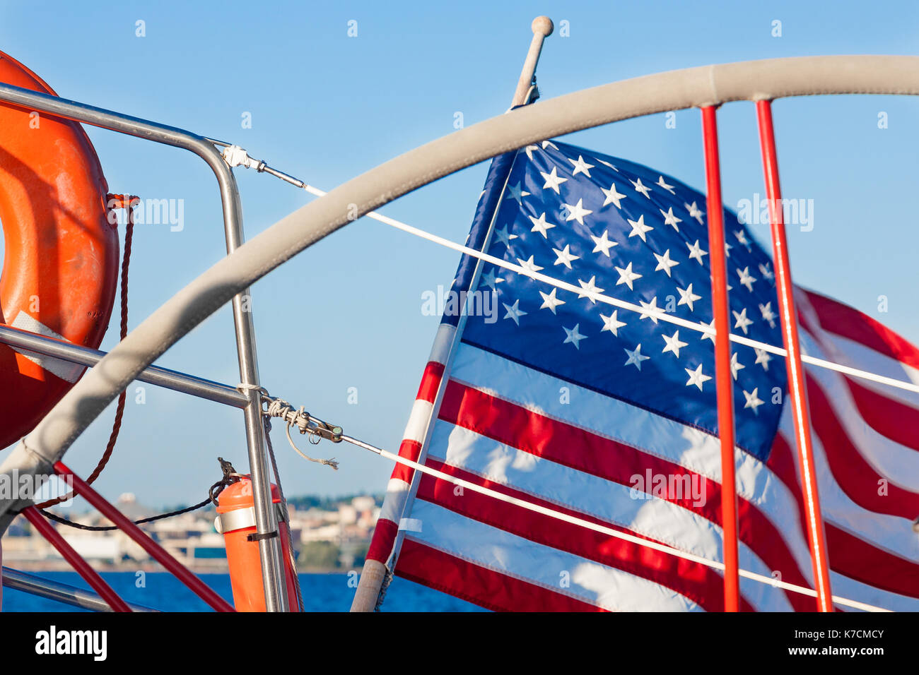 Sailboat steering wheel and American flag close up on the water Stock