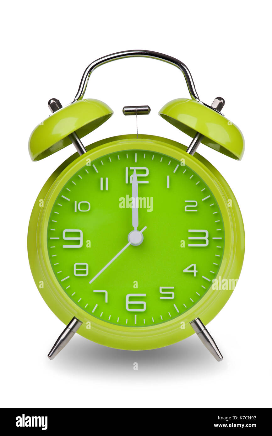 Green alarm clock with the hands at 12 am or pm isolated on a white  background. One of a set of 12 images showing the top of the hour starting  with 1