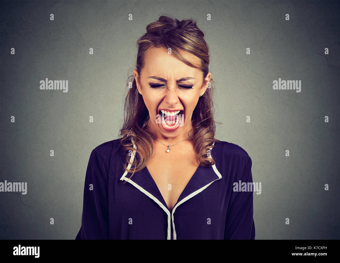 Angry frustrated young woman screaming Stock Photo