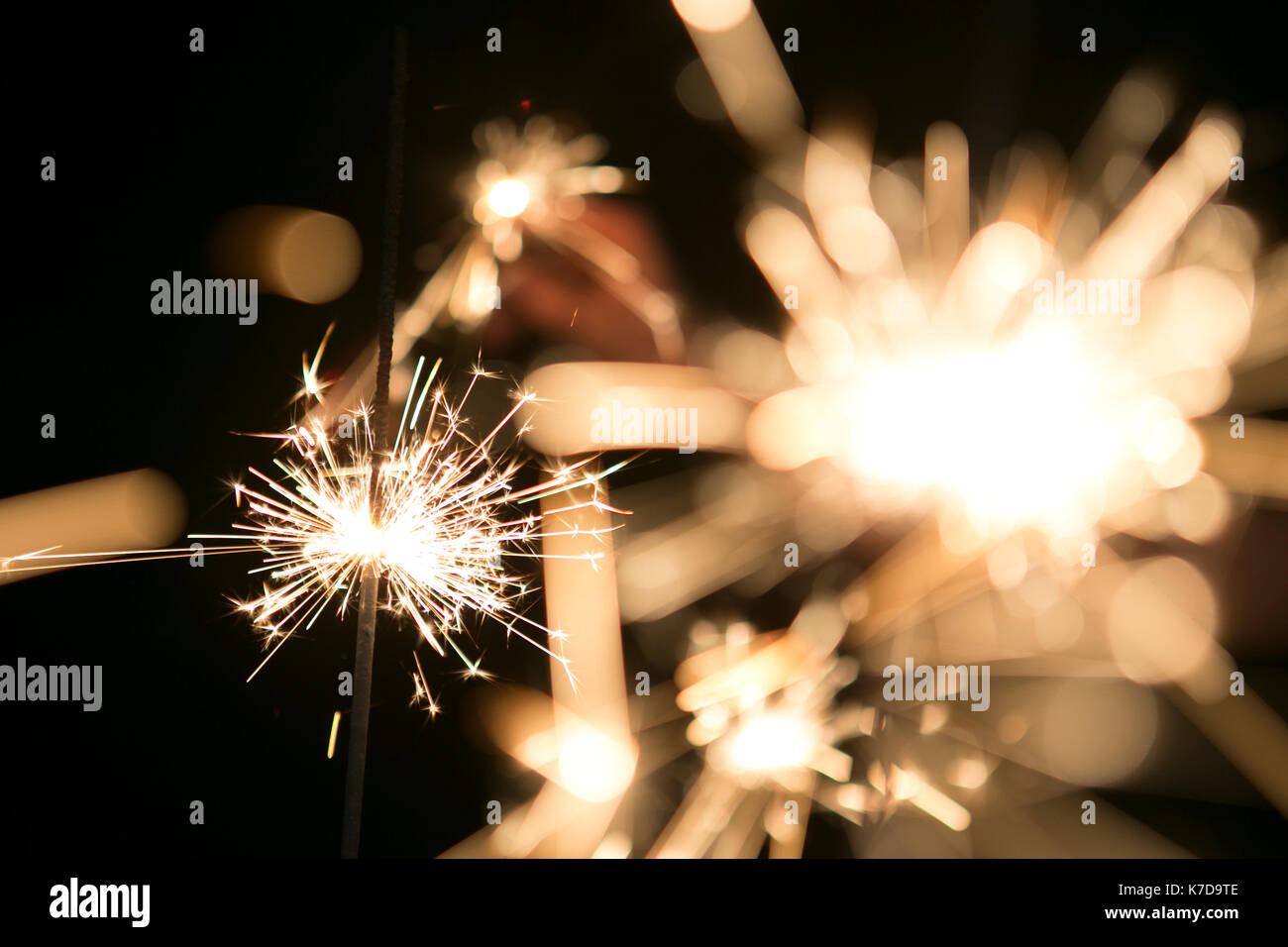 Blurred motion of glowing sparklers at night Stock Photo