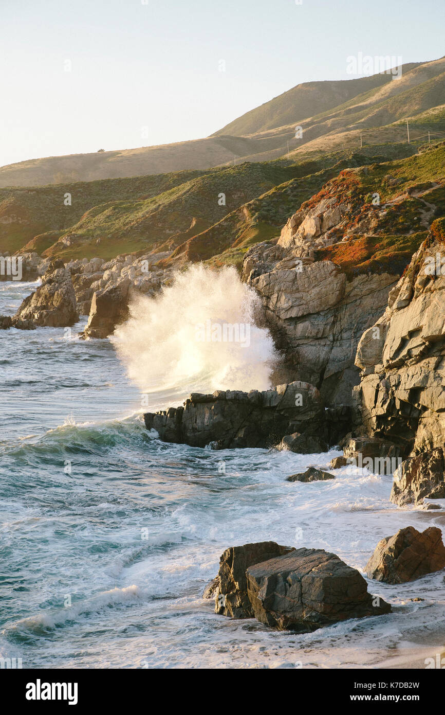 Scenic view of waves breaking on rocks against clear sky Stock Photo