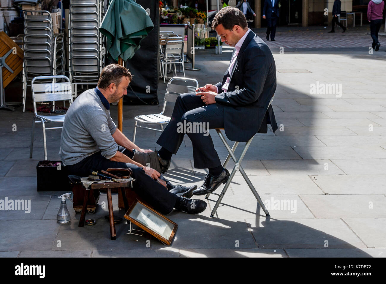 Shoe Shine Man Cleaning A Customers Shoes, Cheapside, London, UK Stock Photo