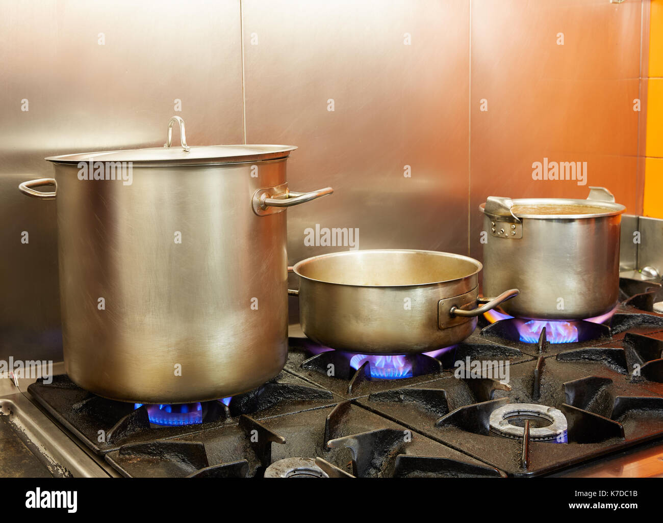 Restaurant pro kitchen with stainless steel pans in fire Stock Photo