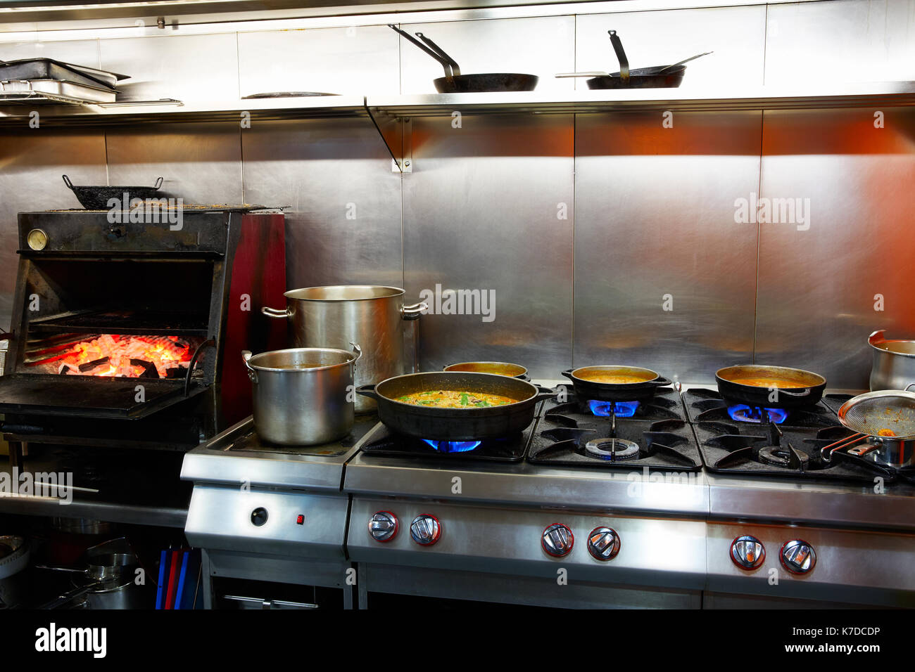 Mediterranean kitchen indoor with paella and flame grill Stock Photo