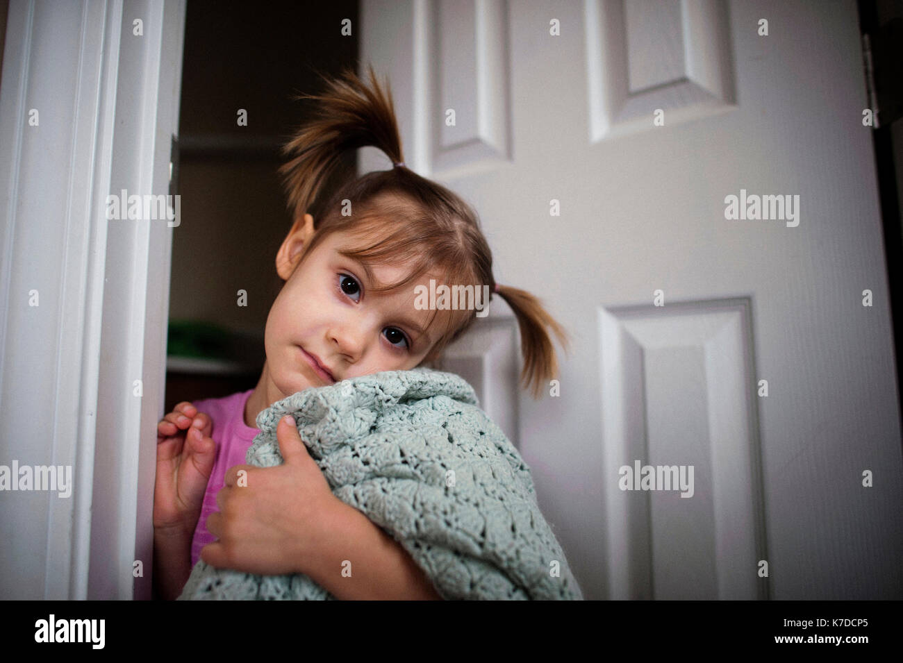Portrait of girl holding shawl while standing at doorway Stock Photo