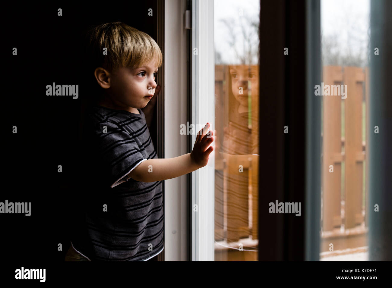 Side view of thoughtful boy looking through window Stock Photo