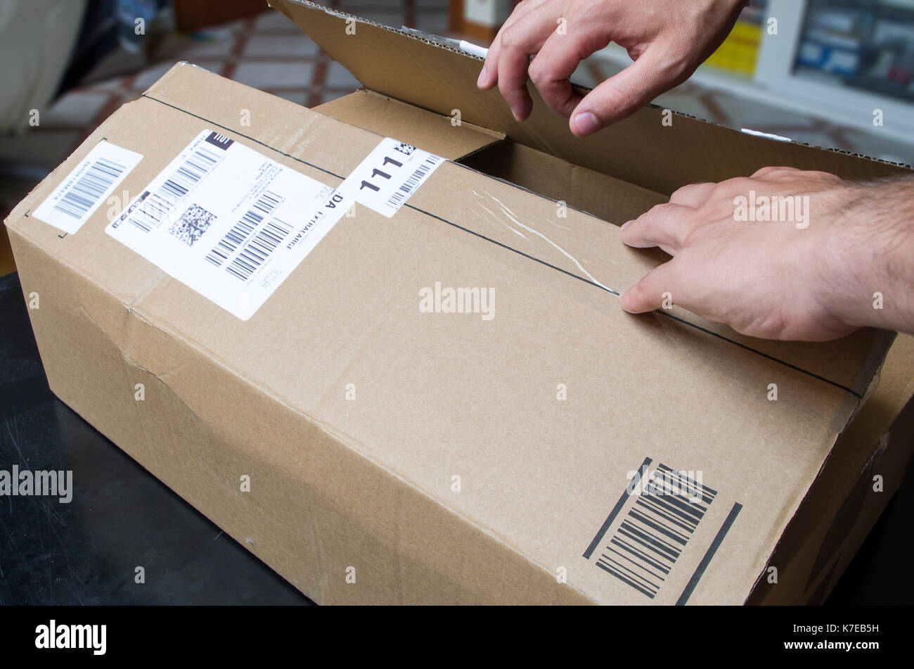 Unpacking a delivery. Hands opening a shipping box Stock Photo