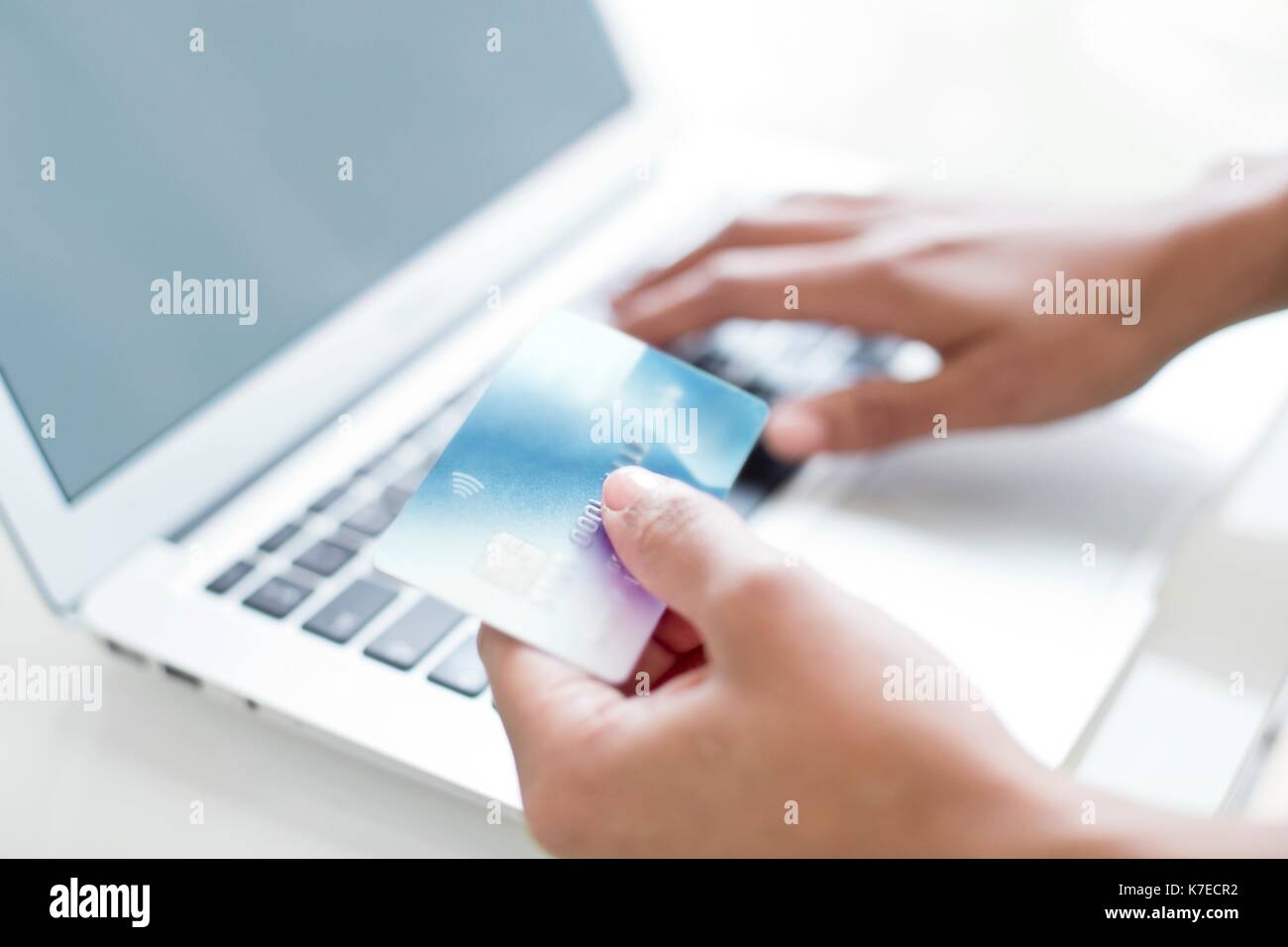 Woman using credit card and laptop. Stock Photo