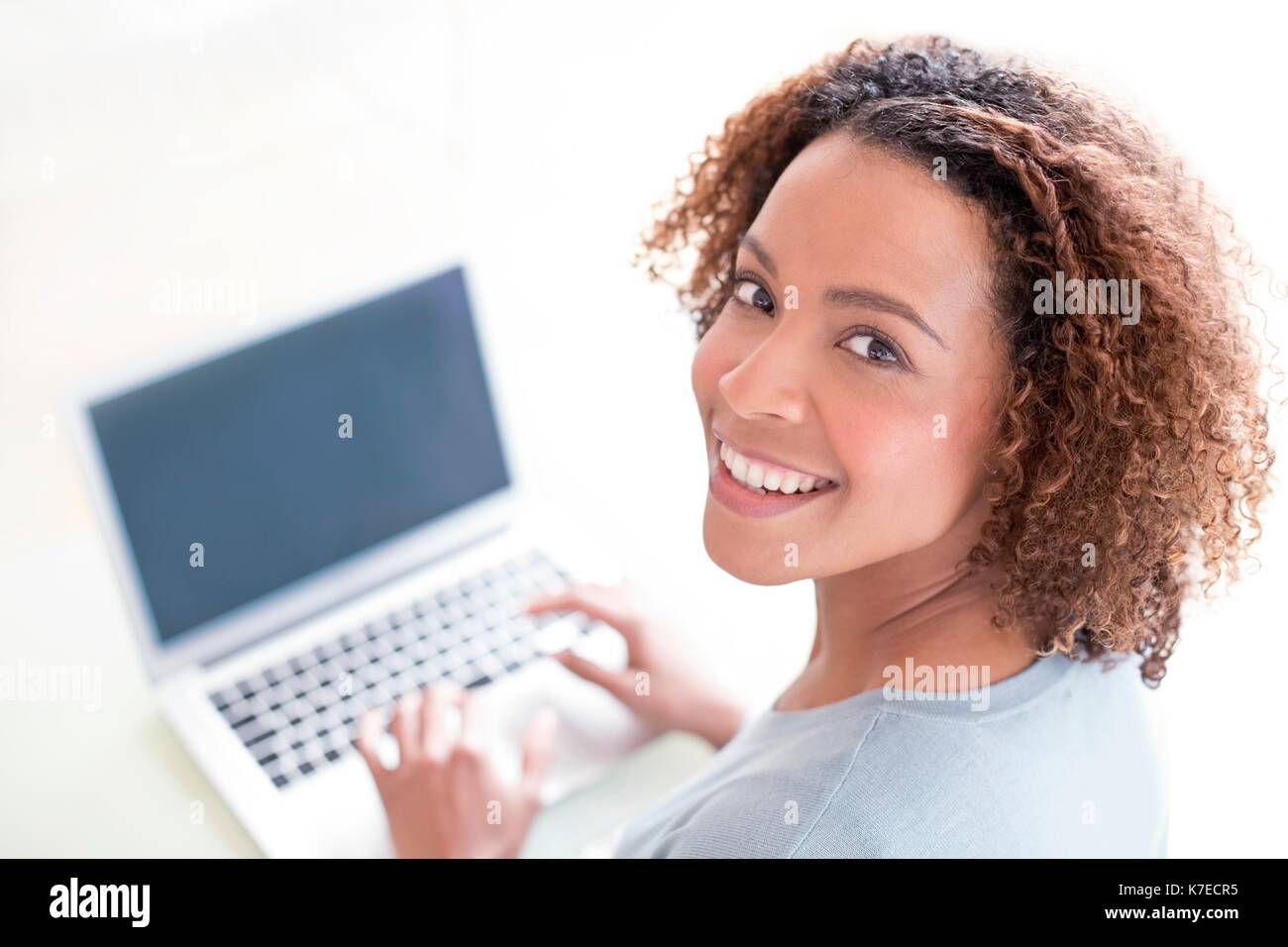 Mid adult woman using laptop. Stock Photo