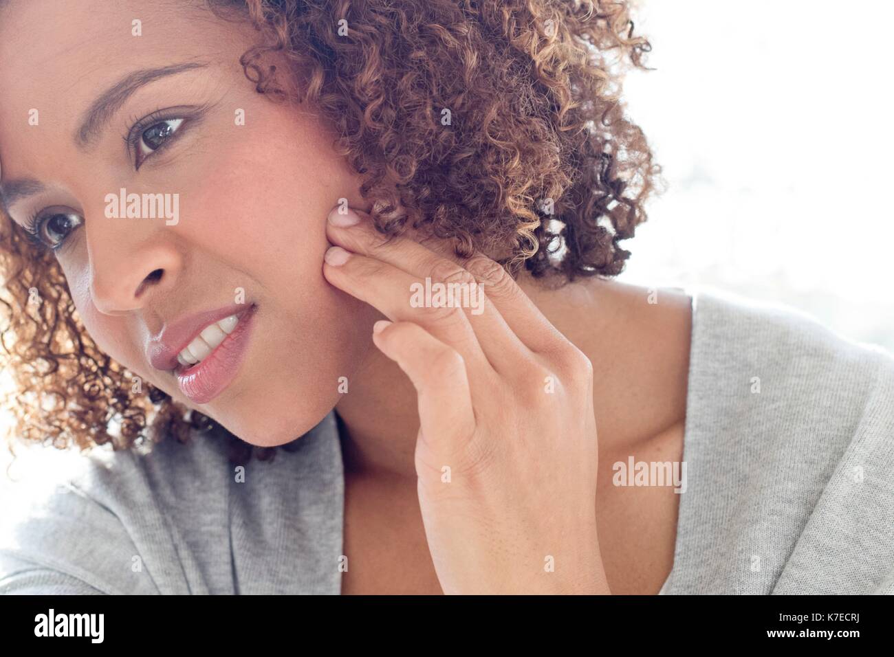 Portrait of mid adult woman touching face. Stock Photo