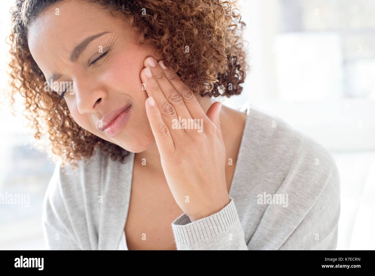 Portrait of mid adult woman touching face. Stock Photo