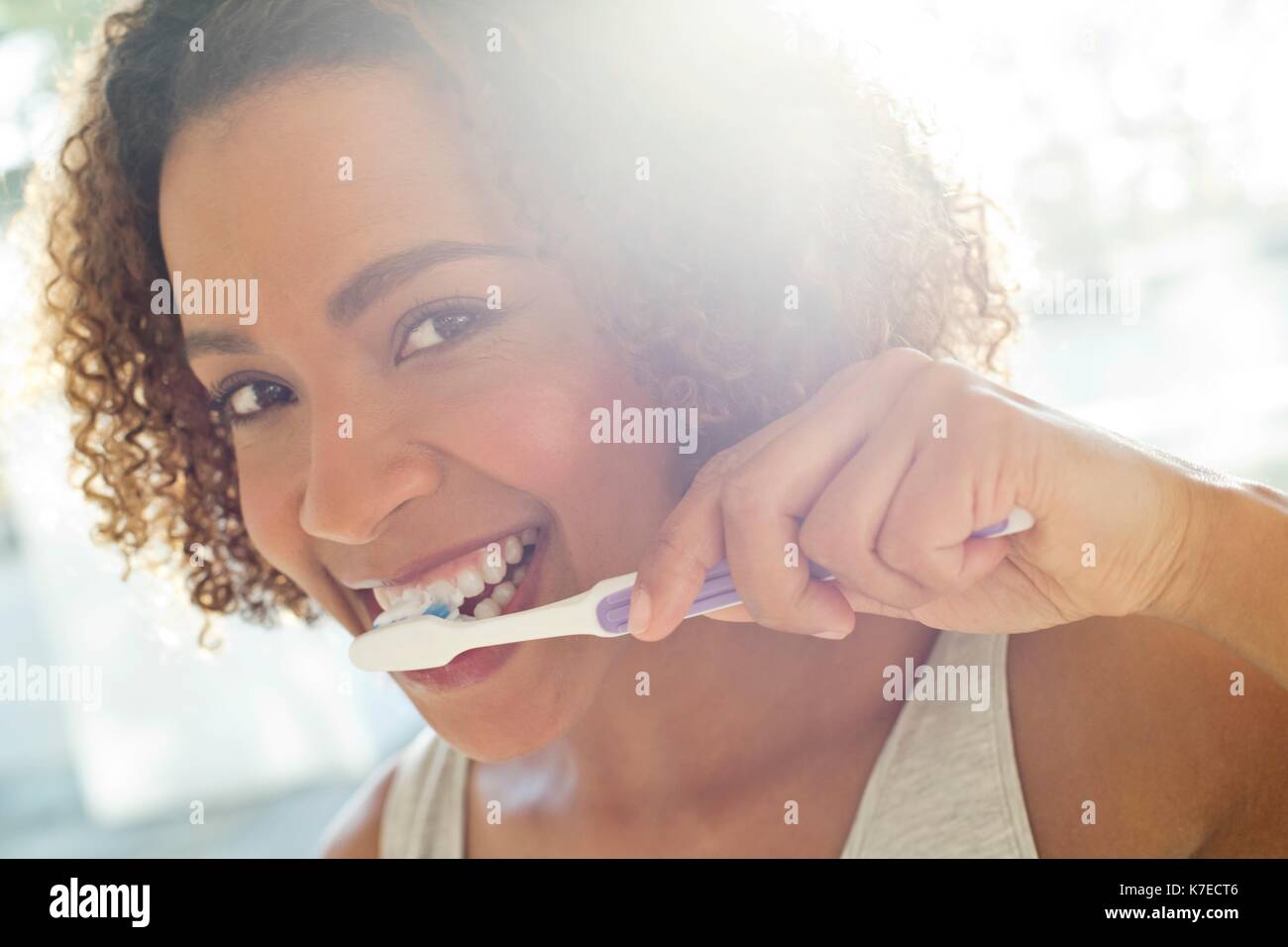 Portrait of mid adult woman brushing teeth. Stock Photo
