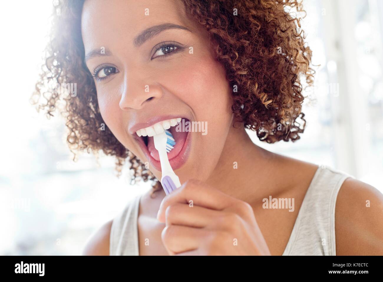 Portrait of mid adult woman brushing tongue. Stock Photo
