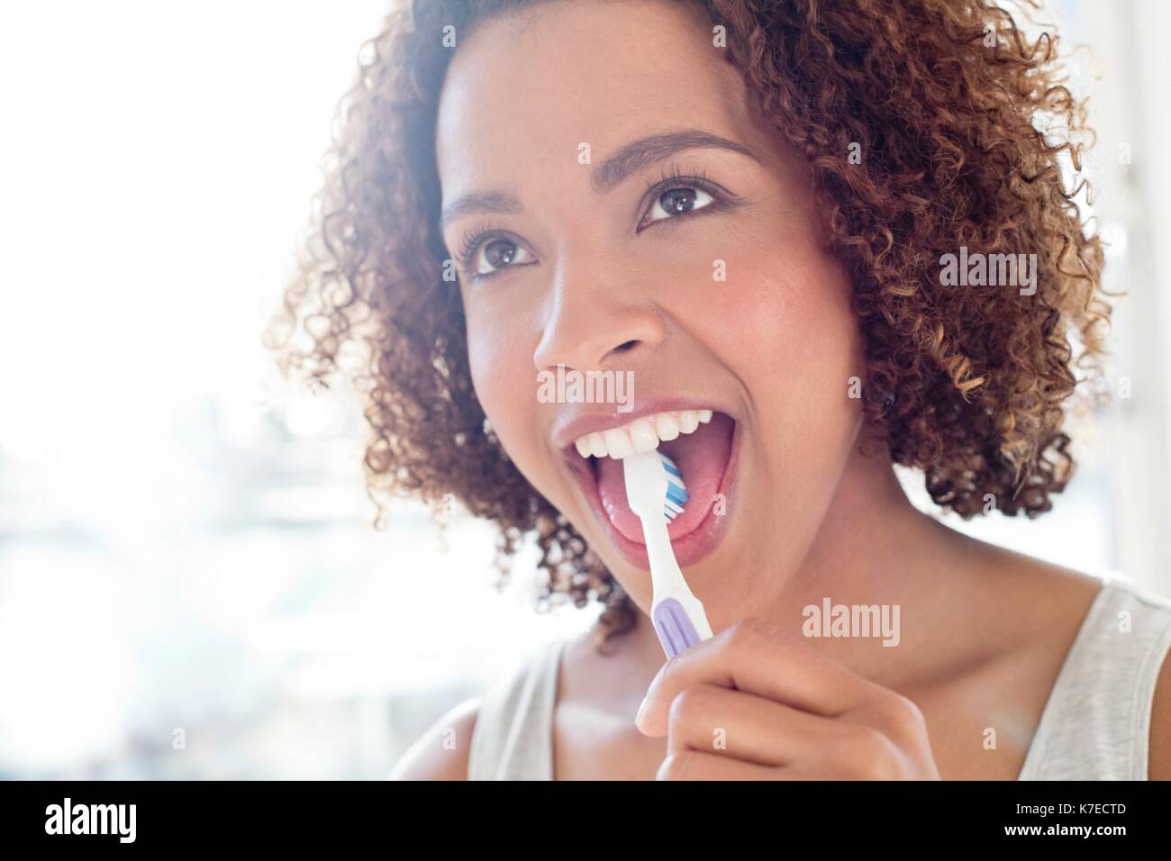 Portrait of mid adult woman brushing tongue. Stock Photo