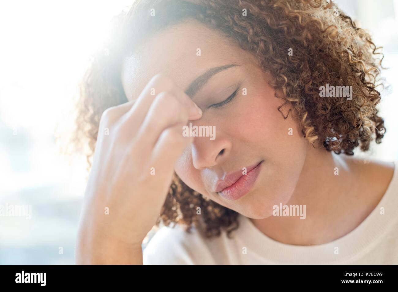 Mid adult woman touching her face. Stock Photo
