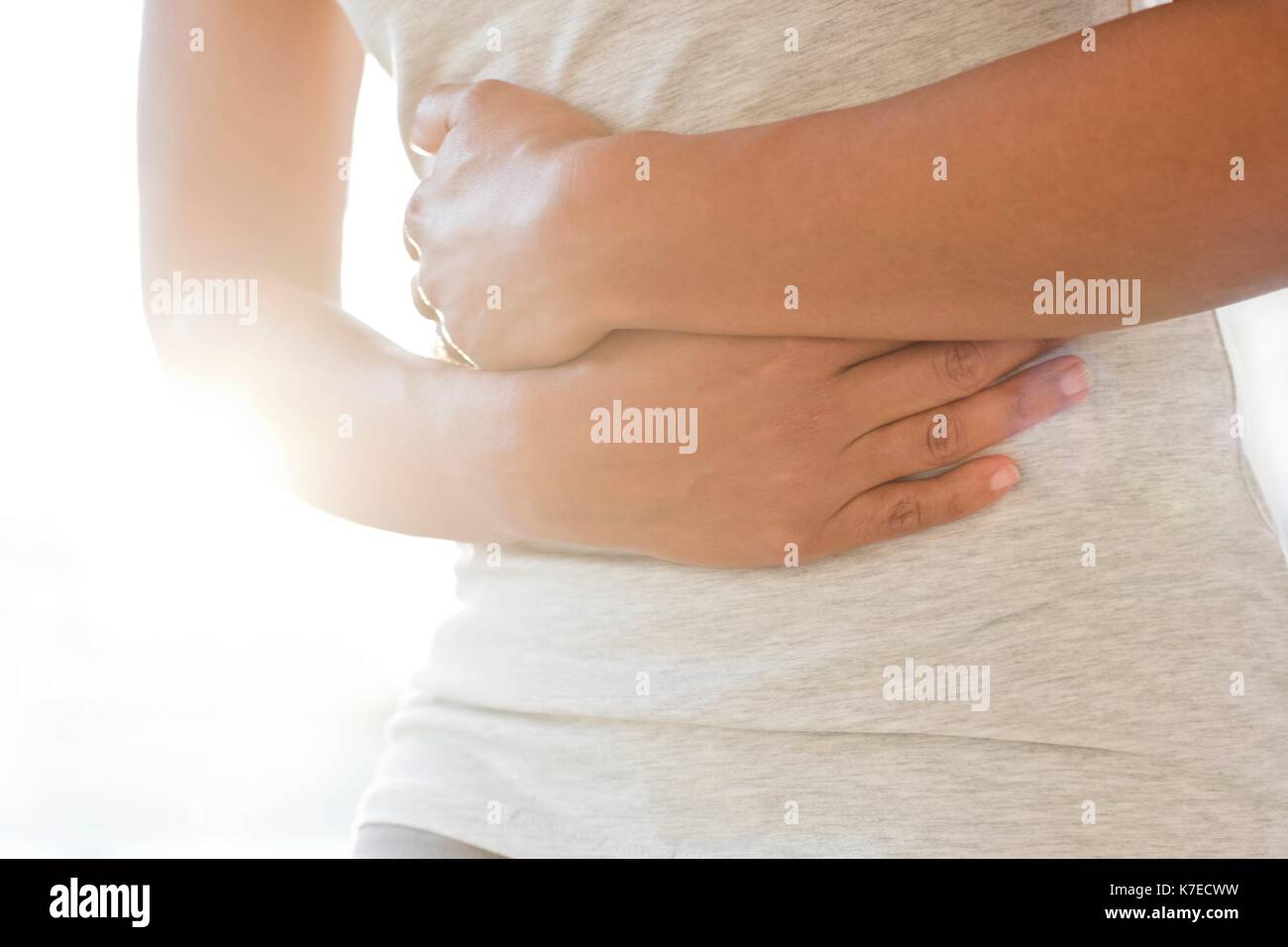Mid adult woman holding stomach. Stock Photo