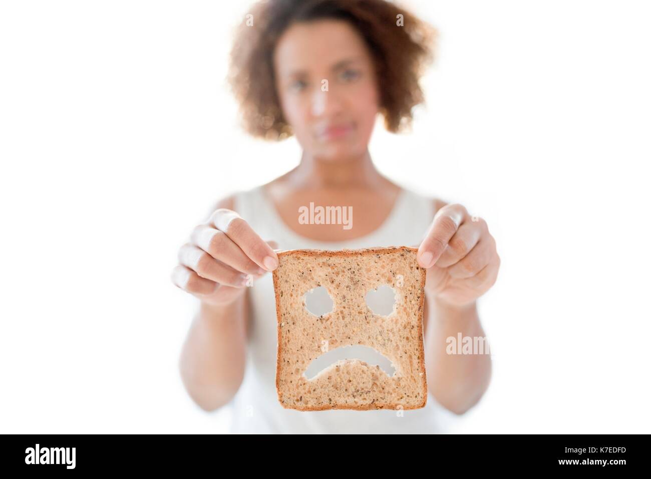 Mid adult woman holding bread with sad face. Stock Photo